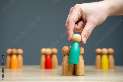 Businessman holding a wooden man in his hand. The concept of market segmentation. Target audience, customer care. Market group of buyers. Customer relationship management. Selective focus