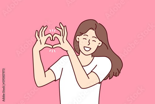 Woman demonstrates gesture of heart made of fingers flirting with boyfriend or beloved husband calling for love and being romantic. Girl shows heart with hands to call for kindness and mercy. 