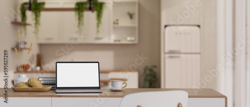 Home workspace with laptop mockup on a table over blurred background of cozy living room.