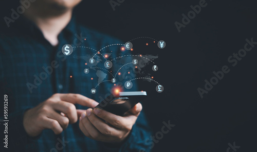 Businessman using telephone with world map and currency sign include dollar euro pound sterling yen yuan won for technology currency exchange and money transfer , Financial and investment concept.