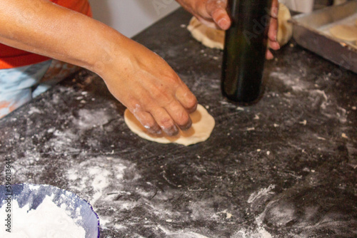 person preparing pizza dough, made in Brazil