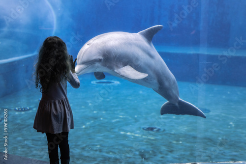 Bambini felici giocano con i delfini durante una visita all' Acquario di Genova, Liguria, Italia, Europa