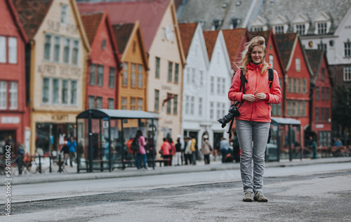 Woman tourist with camera on Bryggen Hanseatic Wharf, Bergen, Norway