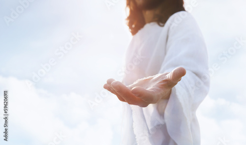 Heaven and cross love and faith and salvation concept of Jesus Christ reaching out with open arms in the sky and the resurrected Jesus Christ 