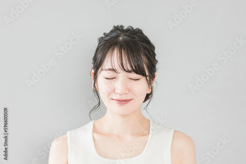 正面から見たアジア人女性の笑顔（美容・エステ・スキンケアイメージ） 