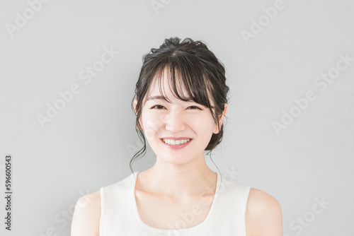正面から見たアジア人女性の笑顔（美容・エステ・スキンケアイメージ） 