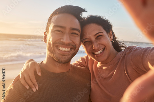 Portrait of a young diverse biracial couple taking a selfie at the beach and having fun outside. Portrait of a young diverse biracial couple taking a selfie at the beach and having fun outside.