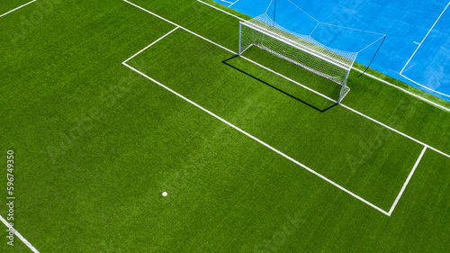Aerial closeup of the penalty spot on an empty synthetic grass soccer field. Here a penalty is taken in a soccer game.