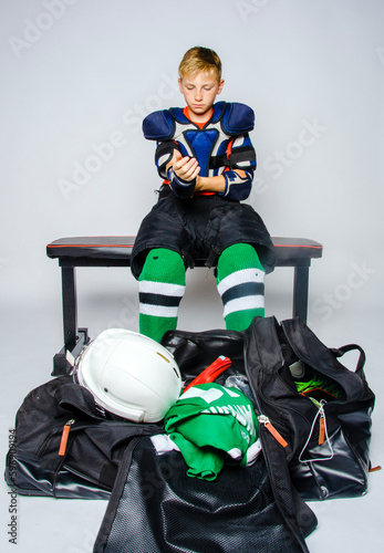 Male youth hockey player getting dressed before a game
