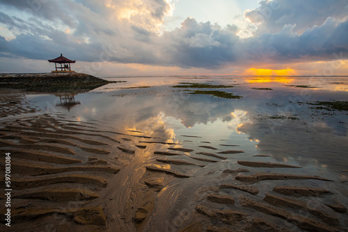 Beautiful, peaceful, and tranquil sunrise view in Sanur Beach, Bali, Indonesia. Sanur beach is a popular tourist destination in the famous Bali Island in Indonesia, there are some gazebos for tourist.