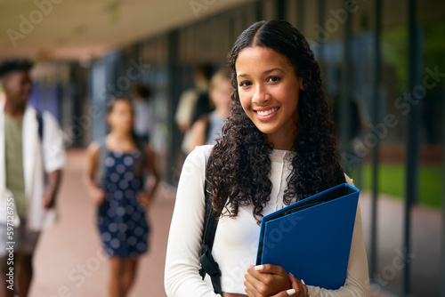 Portrait Of Female Secondary Or High School Student Outdoors At School Walking To Class