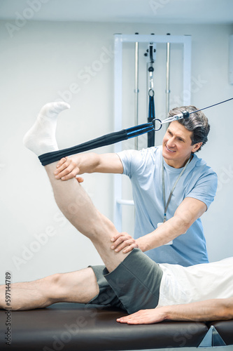 Physal therapist working with patients limb hyperextension