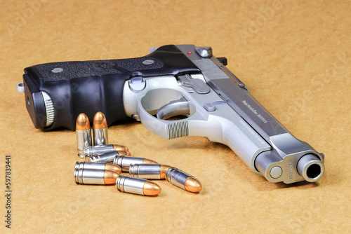 bullet 9mm parabellum and Beretta 92FS, M9 gun on brown paper background.