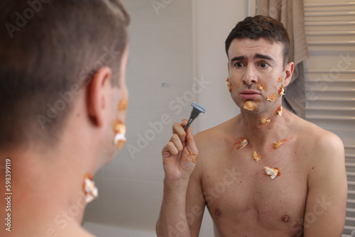 Humorous image of clumsy man shaving his beard 