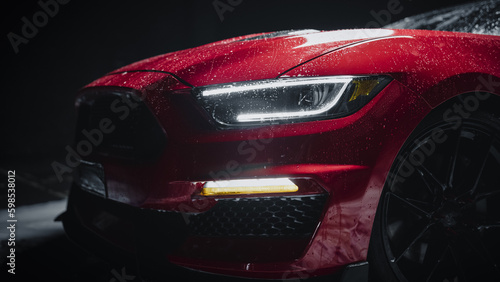 Close Up of a Modern Red Performance Car in a Dark Studio Environment. Creative Led Headlights Photo of a Performance Sportscar Dripping in Water After a Detailed Car Wash