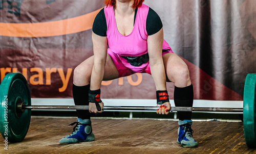 woman powerlifter performing deadlift in powerlifting competition, power sports games
