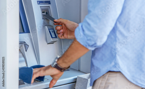 Man using an cash dispenser on the street, close up photo