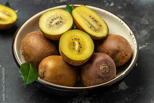 Whole and cut golden kiwifruit on a dark background, Healthy food concept. place for text, top view