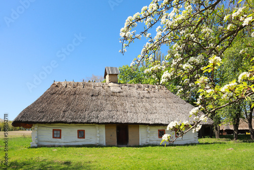 Whitewashed house with a thatched roof from Middle Transnistria in skansen Pirogovo in Kyiv, Ukraine 