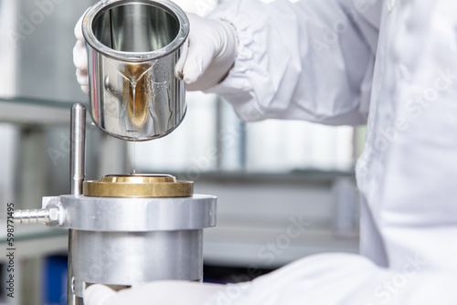 Personnel in the laboratory are mixing industrial glue,test glue properties,wearing gloves, professional protective clothing(raw material for paint)