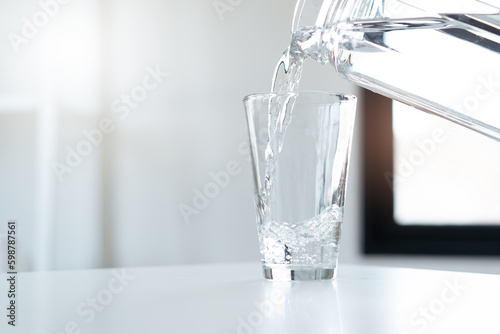 woman pouring down mineral water to glass.