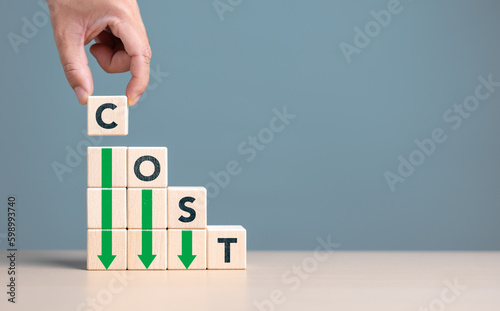 Lean or Cost reduction concept. Optimize manufacturing management. Decreasing company expense to maximize profits. Hand puts wooden cube with words cost and green down arrows. Business improvement.