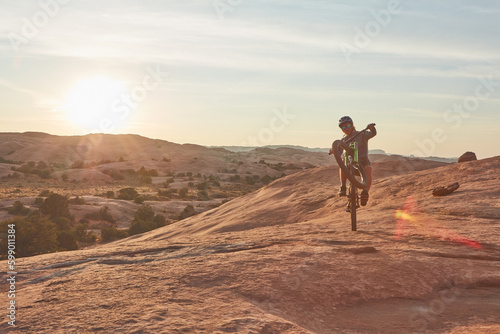 Staying fit doesnt have to be boring. Full length shot of a young male athlete popping a wheelie while mountain biking in the wilderness.