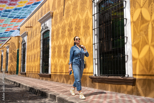 Una joven está caminando por una calle del casco histórico de Etzatlán y tiene el Cielo Tejido más grande del mundo.