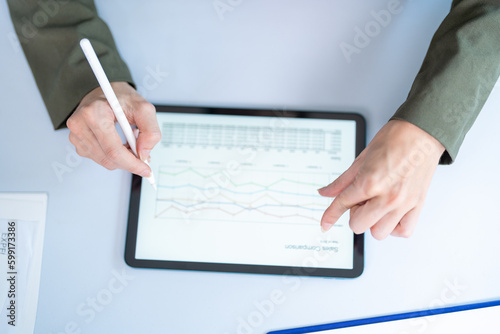 Woman working with laptop at home desk, close-up