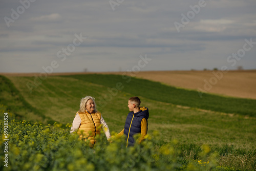 Portrait of a smiling grandmother and grandson hugging near a field