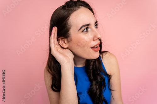 Woman with her hands on her ears trying to hear better.