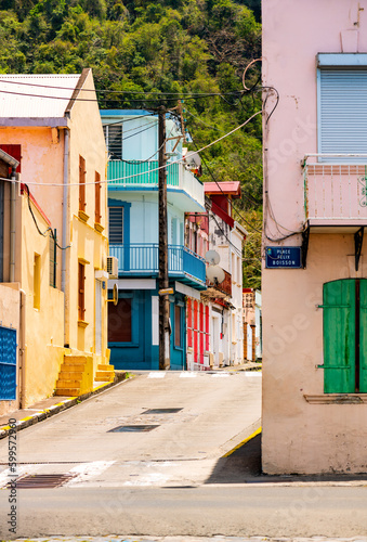 Colorful facades of houses on the waterfront of Saint Pierre on tropical island Martinique (France, Lesser Antilles). Idyllic atmosphere with narrow one way streets on a sunny day in tourist village.