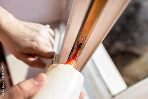 lubricating of open window frame close up at home on sunny day