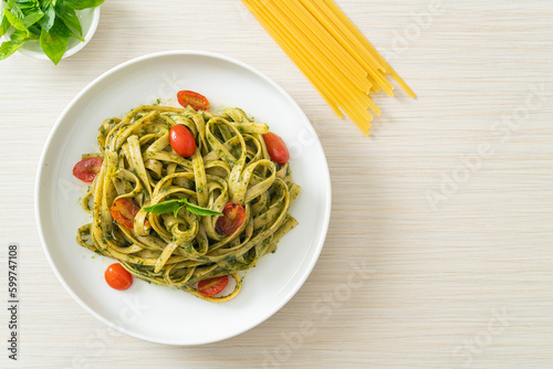 fettuccine spaghetti pasta with pesto sauce and tomatoes