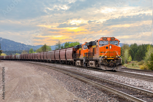 freight train with a colorful sunset in background near Whitefish, Montana
