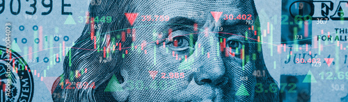 Closeup Benjamin Franklin face on USD banknote with stock market chart graph for currency exchange and global trade forex concept.