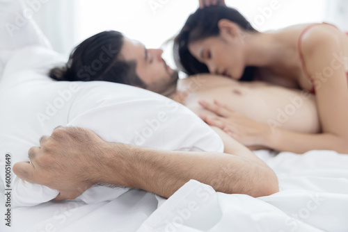 Selective Focus on A Man Hand Grab Bed Sheet with Woman Seduce a Man on the Bed