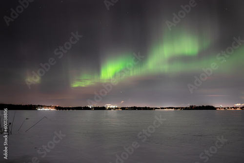 Enchanting Frozen Lake: Vibrant Green Aurora Illuminating the Night Sky