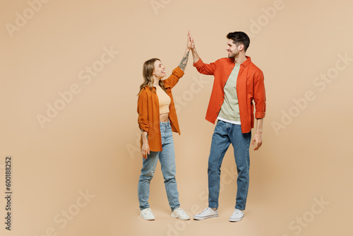 Full body young couple two friends family man woman wear casual clothes together meeting together greeting giving high five clapping hands folded isolated on pastel plain light beige color background.