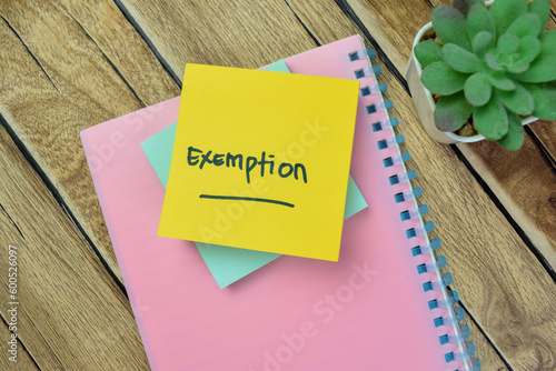 Concept of Exemption write on sticky notes isolated on Wooden Table.