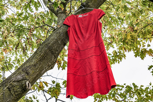 BURLINGTON, ONTARIO, CANADA - JUNE 28, 2019: A red dress hangs in a tree in Spencer Smith park as part of The Red Dress Project for Missing and Murdered Indigenous Women