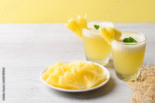 Pineapple smoothie in glass with sliced pineapple fruit, Tropical summer drink
