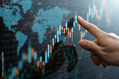 Graphs and world financial markets data. Investor pointing at the candlestick chart.