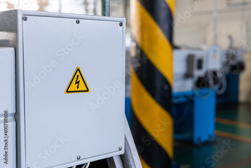 Hight voltage sign on machine at industrial plant. Occupational and safety caution sign for worker in factory concept.