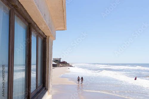 Vista panoramica de personas caminando por la playa a lo lejos.