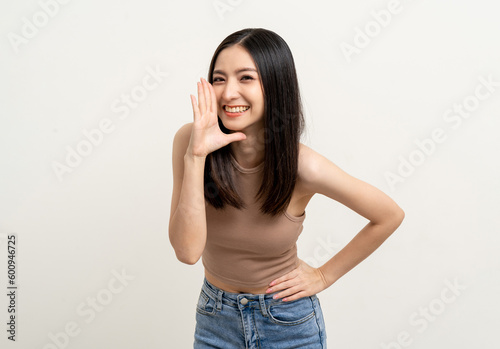 Happy beautiful asian woman with copy space. Excited pretty girl shout out loud wow with hands on mouth announcement standing pose on isolated white background.