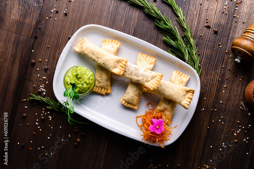 Minced meat in dough with guacamole and carrots, pasties in plate.