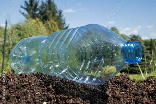 pusta butelka plastikowa leżąca na ziemi bez śmietnika.
