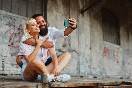 Young happy couple taking a selfie in an urban environment