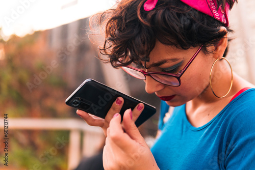 manos de chica sujetando y hablando en un celular, enviando mensajes y escribiendo en la ciudad